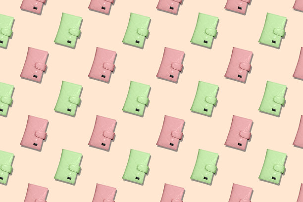 粉色背景上粉绿相间的女性时尚钱包无缝图案。图片下载