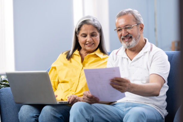 快乐的成熟夫妇使用笔记本电脑，同时计划他们的家庭预算库存照片图片下载