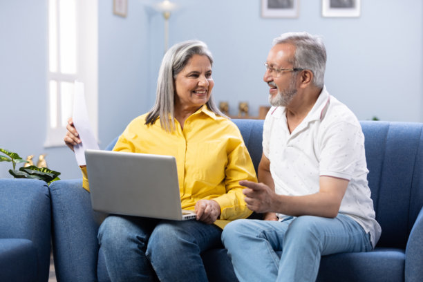 快乐的成熟夫妇使用笔记本电脑，同时计划他们的家庭预算库存照片图片下载