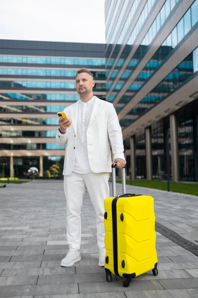 专注的年轻企业员工投资者在商业中心附近走动并使用手机。图片下载