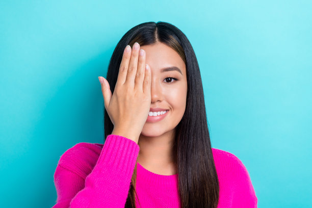 特写照片，漂亮积极的女士穿着漂亮的衣服，手臂掌心闭眼检查视力，眼科医生背景为青色。图片下载
