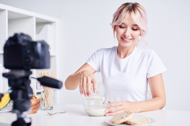微笑的女性正在为早餐制作牛奶麦片。图片下载