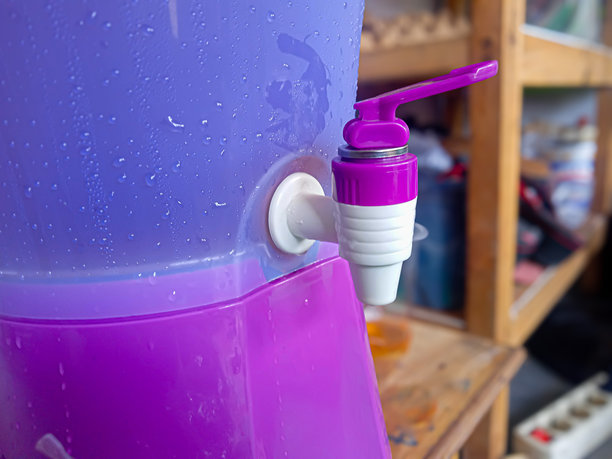 紫色塑料水龙头在冰水容器中图片下载