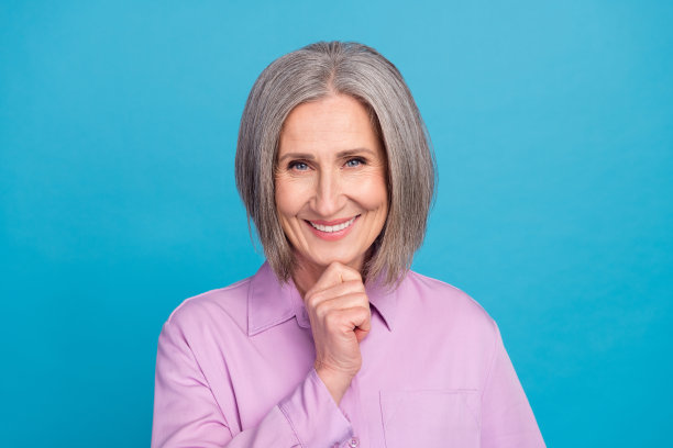 穿着时尚的聪明老年女士在蓝色背景下思考、决定问题并寻找解决方案的照片图片下载