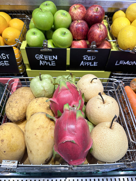 超市货架上的农产品：亚洲梨、火龙果、苹果芒果、胡萝卜、新奇士橙、苹果和柠檬图片下载