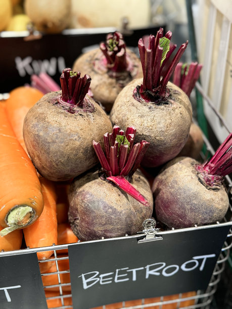 超市货架上蔬菜的特写图像，黑色纸板标签上夹着蔬菜名称，夹在铁丝储物篮上，甜菜（Beta vulgaris）和胡萝卜（Daucus carota），在超市出售。图片下载
