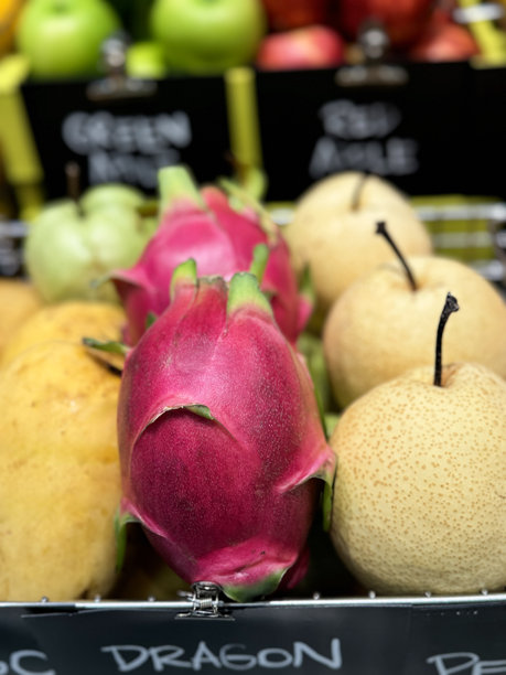 超市货架上的农产品特写：亚洲梨、火龙果和苹果芒果图片下载