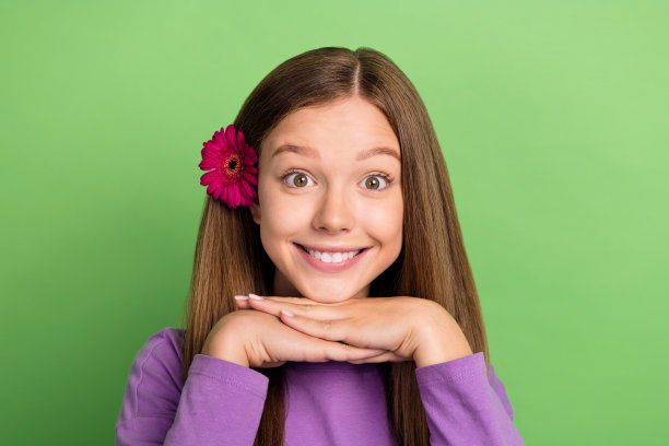 特写照片，迷人而愉快的女士穿着时尚的紫色衣服，享受春天的时光，背景为绿色。图片下载