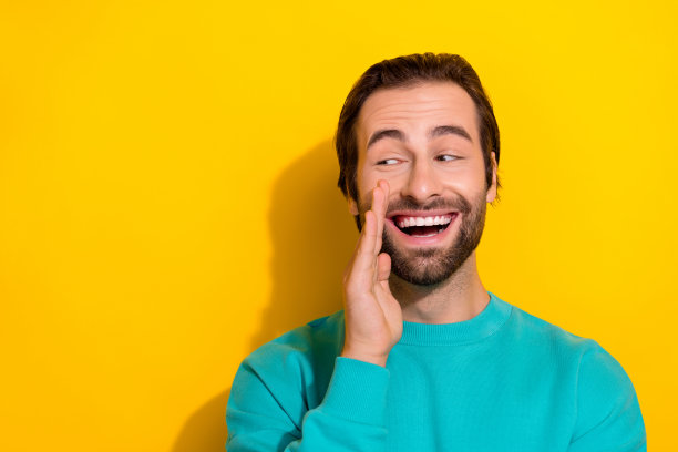 穿着青色服装的阳光甜美男孩在黄色背景下望向空旷的地方，似乎在倾诉秘密。图片下载