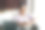 愉快、微笑的超重成熟黑人女性戴着眼镜，坐在厨房桌旁，手中捧着白色咖啡杯，透过窗户欣赏外景，享受热饮，刚刚在笔记本电脑上工作完。图片下载