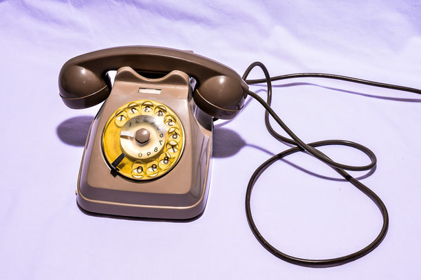 一部带有黄色拨号盘的复古电话放置在白色背景上图片下载