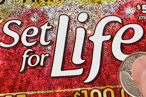 特写镜头：一位女性正在刮刮乐彩票，彩票名为“终身赢家”图片下载