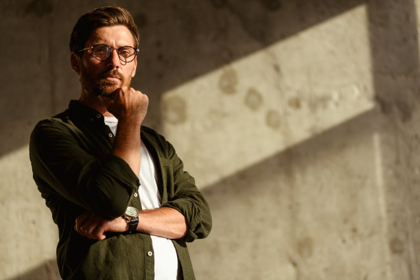 成年室内设计师在模糊的混凝土墙旁看向镜头的肖像图片下载