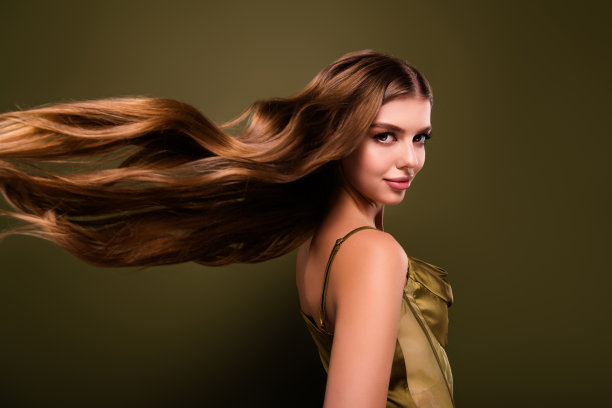 经过角蛋白疗法效果的迷人漂亮女士的照片，背景为卡其色。图片下载