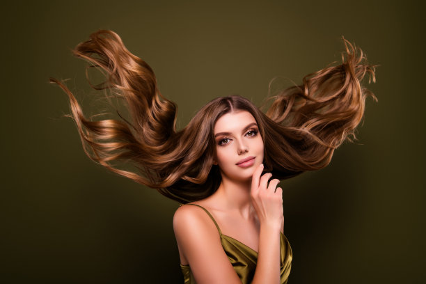 一位迷人、可爱、优雅、温柔的女士，长发健康，背景为卡其色。图片下载