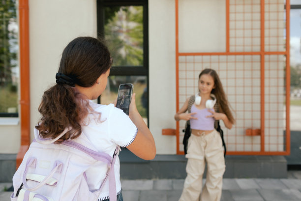 多元文化的小学女生同学们穿着休闲服装，背着书包在学校操场上自拍。属于Z世代的一部分。系列作品之一。图片下载