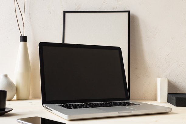 舒适的家庭办公室桌子，上面有笔记本电脑和杯子，背景是明亮的沙质纹理墙壁图片下载