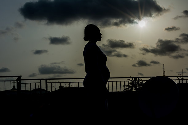 日落时分，孕妇的剪影站在天空前图片下载