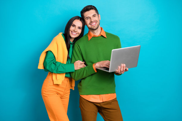 积极的情侣使用数字笔记本电脑在蓝色背景下搜索购买情人节礼物的照片图片下载