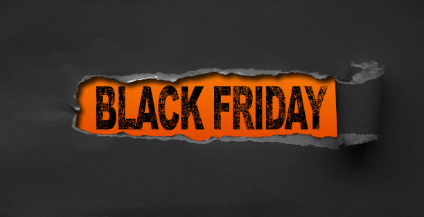 黑色撕裂纸张的俯视图，上面有“黑色星期五”的文字，背景为橙色。黑色星期五的构图。图片下载