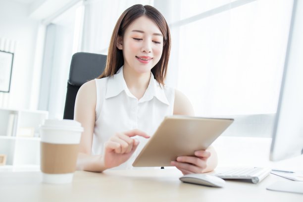 自信的女商人在办公室的桌子前使用数字平板电脑图片下载