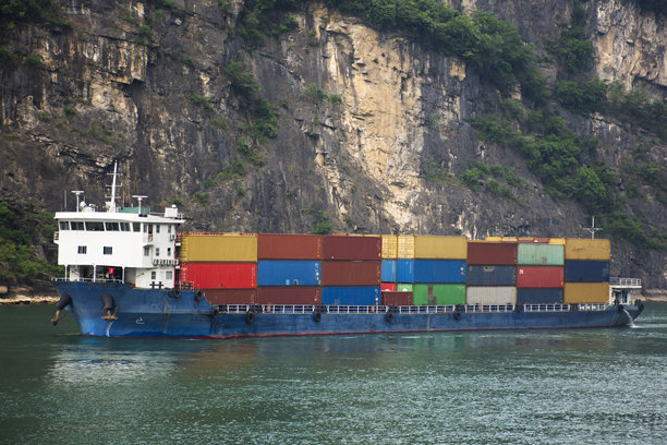 在中国湖北省宜昌市西陵峡，中国人驾驶风帆驳船和拖船货船在长江上与长江三峡山崖之间运送货物图片下载