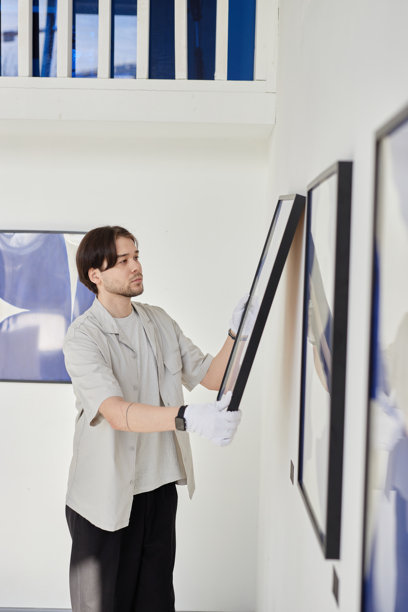 亚洲男子悬挂图片，策划艺术画廊展览图片下载