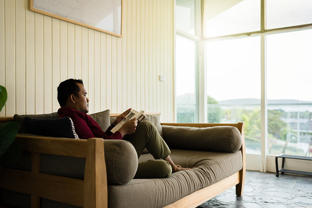 男人坐在家里的沙发上阅读书籍图片下载