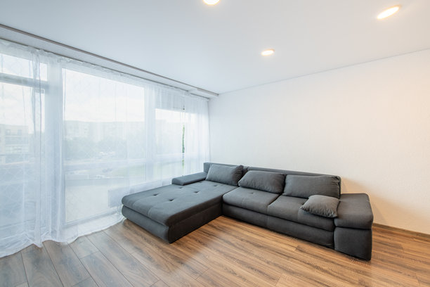 现代家居客厅与窗户、阳台。奢华时尚的现代公寓。开放式室内，时尚沙发，沙发床。斯堪的纳维亚设计。硬木地板。图片下载
