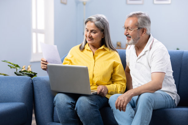 快乐的成熟夫妇使用笔记本电脑，同时计划他们的家庭预算库存照片图片下载