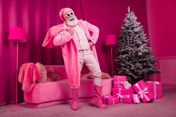 有趣的退休老人的照片圣诞老人携带麻袋毛皮大衣靴子蓬松的睡衣帽子太阳镜粉红色的圣诞派对装饰室内圣诞节图片下载
