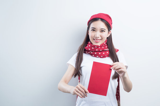 美丽的女人戴着节日帽子，拿着红包庆祝中国新年图片下载