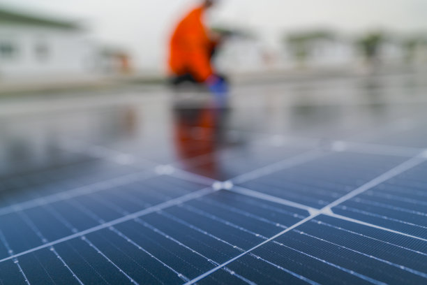 工程师检查太阳能电池板或光伏电池的施工，使用电子设备。工业可再生能源的绿色电力。工人在塔楼屋顶上工作。图片下载