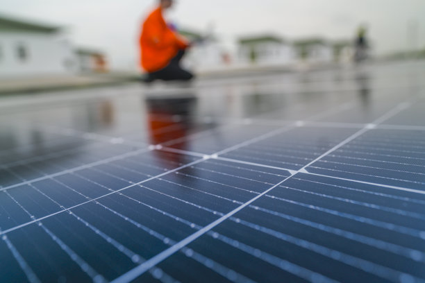 工程师检查太阳能电池板或光伏电池的施工，使用电子设备。工业可再生能源的绿色电力。工人在塔楼屋顶工作。图片下载