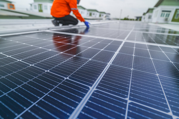 工程师检查太阳能电池板或光伏电池的施工，使用电子设备。工业可再生能源的绿色电力。工人在塔楼屋顶工作。图片下载