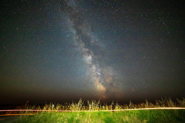 乡村风景中的银河系核心，摩托车留下的光轨。图片下载
