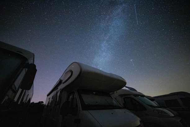 银河系在过夜停放的露营车上方。图片下载