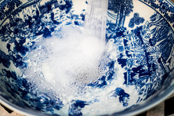 公共洗手间中，水流入装饰有中国古董陶瓷设计的水槽的特写照片，泰国查安。图片下载