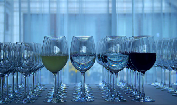 优雅的水晶酒杯整齐排列，桌布上摆放着各种葡萄酒图片下载