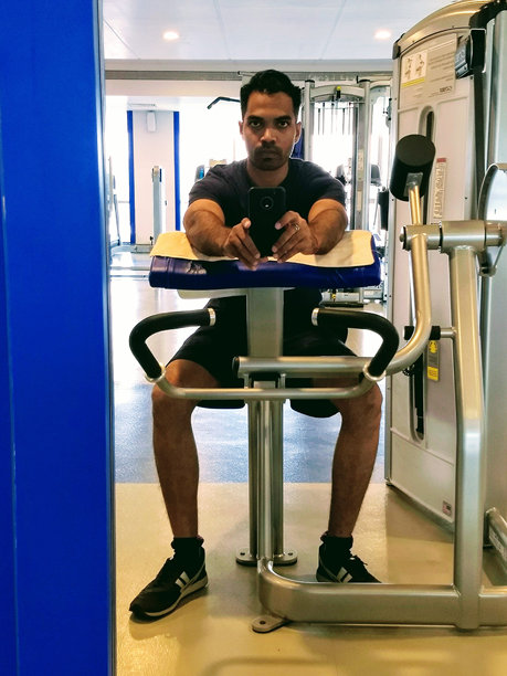 年轻男子在健身房拍镜子自拍照图片下载