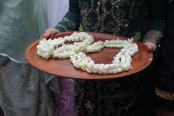 特写照片，展示了托盘上的茉莉花项链。图片下载