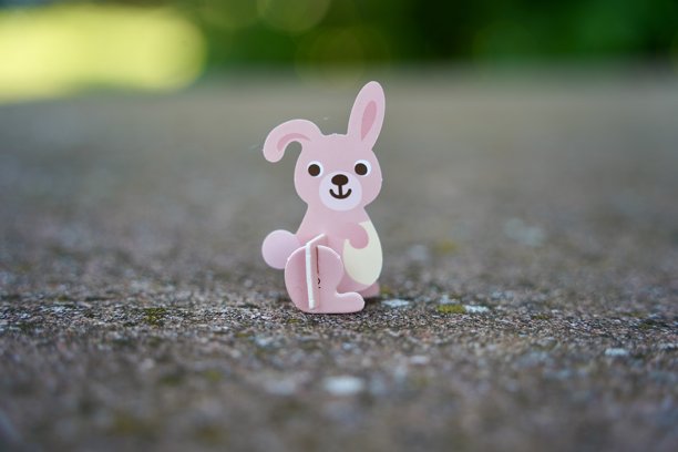 可爱的小粉色兔子纸板玩偶。动物雕像玩具。图片下载