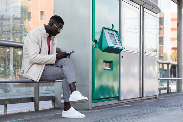 黑人男性企业家在火车站台上浏览智能手机图片下载