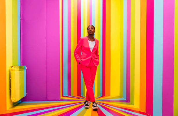 年轻女性全身肖像，站在墙边图片下载