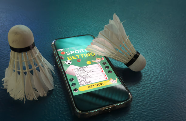 一把羽毛球拍和一部带有体育博彩的智能手机图片下载