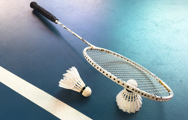 破损的羽毛球拍和使用过的白色羽毛球放在紫色的球场地板上，柔和且选择性对焦，面向全球羽毛球爱好者的概念。图片下载