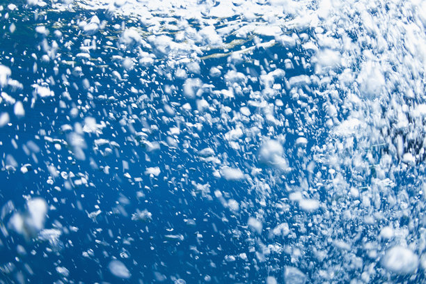 蓝色海洋中的气泡。抽象的水下照片。潜水员背景图片下载