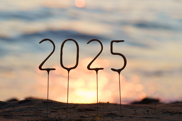 2025年数字插在海滩上，背景是闪耀的蓝色海水和日落。庆祝新年和圣诞节的概念，祝愿成功和灵感。图片下载