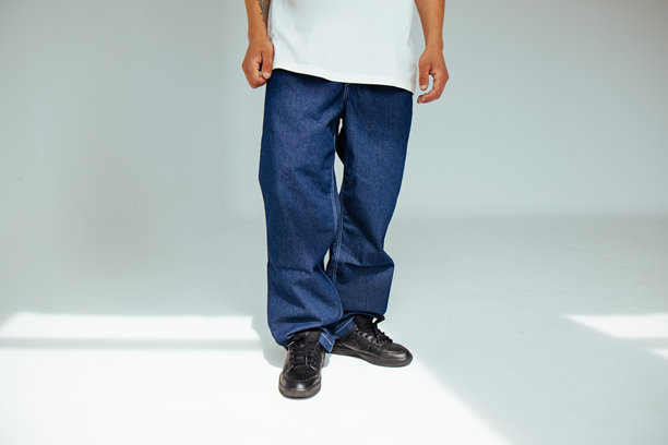 时尚前卫的人的概念，男模特穿着合身的深蓝色普通牛仔裤。该设计展示了日常黑色牛仔服装的舒适和风格。图片下载