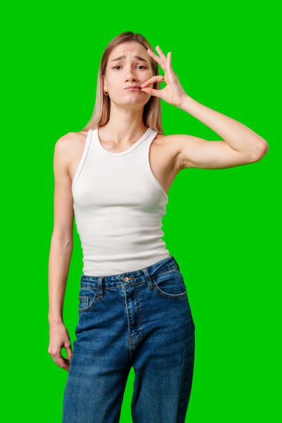 年轻女子对着绿幕做着严肃的沉默手势图片下载